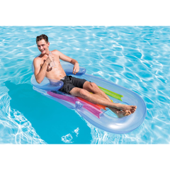 Person lounging on a colorful inflatable pool raft in clear blue water